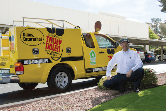 Truly Nolen professional beside a service vehicle.