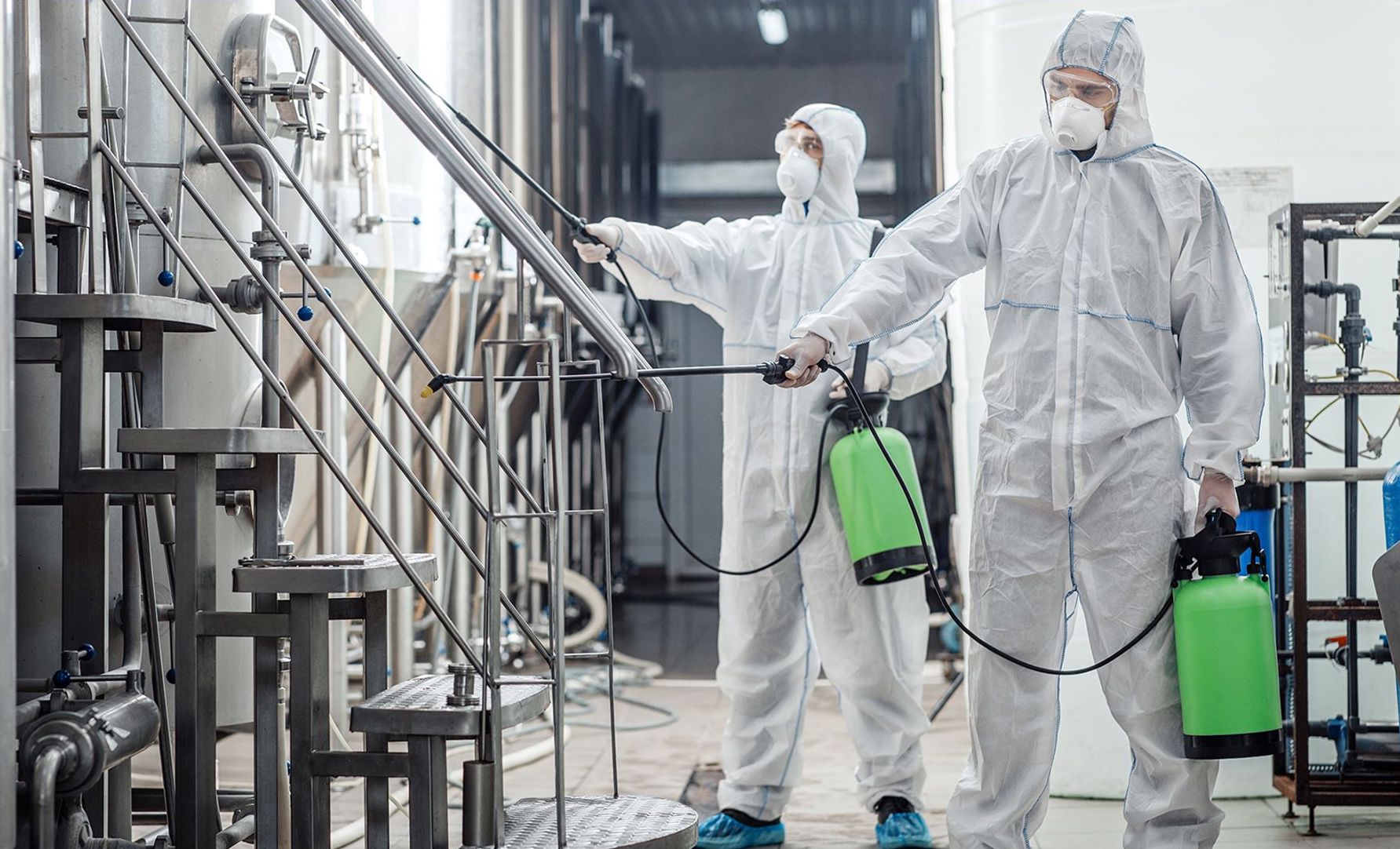 Staff in protective equipment applying a treatment in an industrial facility; sanitization service photograph published by TNI